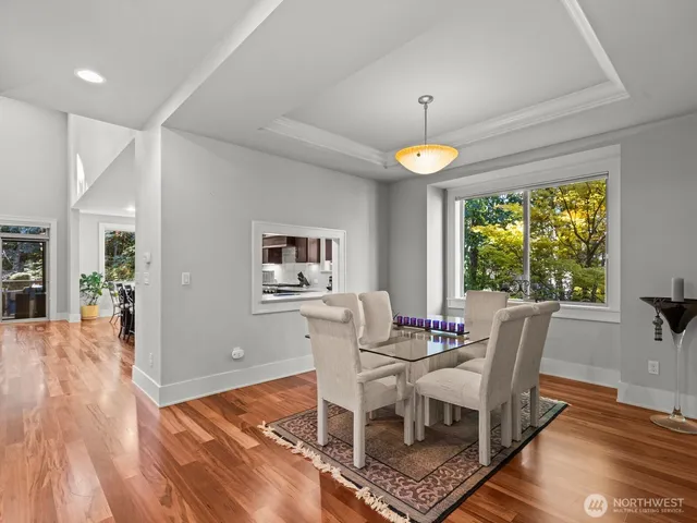 a dining room with furniture a rug a chandelier and wooden floor