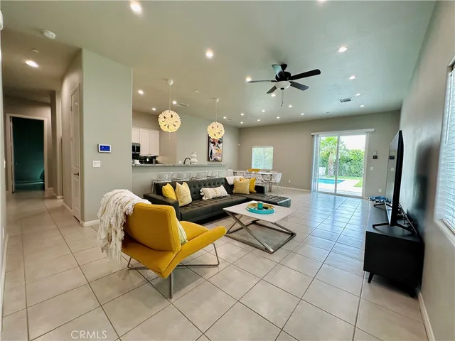 a living room with couches and kitchen view with wooden floor