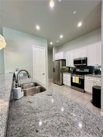 a kitchen with stainless steel appliances granite countertop a sink a stove and a refrigerator