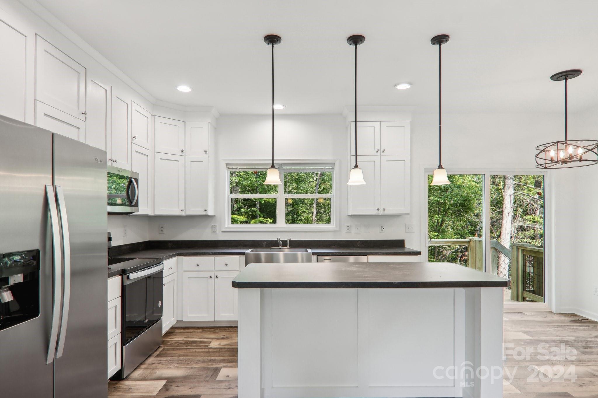 1730 Windswept Ridge Road Marshall, NC 28753 - Photo 11 of 45 a kitchen with stainless steel appliances granite countertop a refrigerator a sink and white cabinets