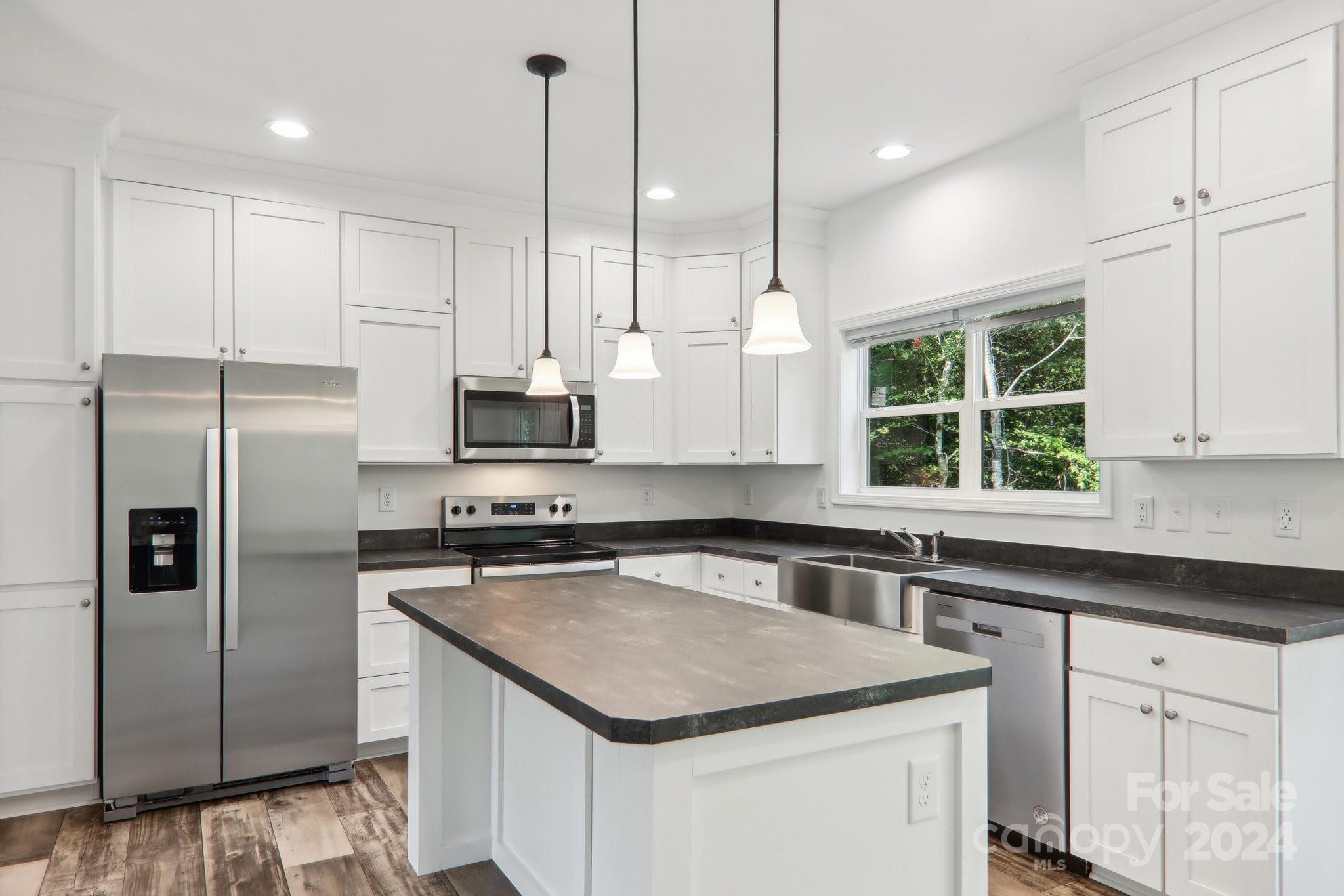 1730 Windswept Ridge Road Marshall, NC 28753 - Photo 13 of 45 a kitchen with stainless steel appliances granite countertop a sink a stove a refrigerator and window