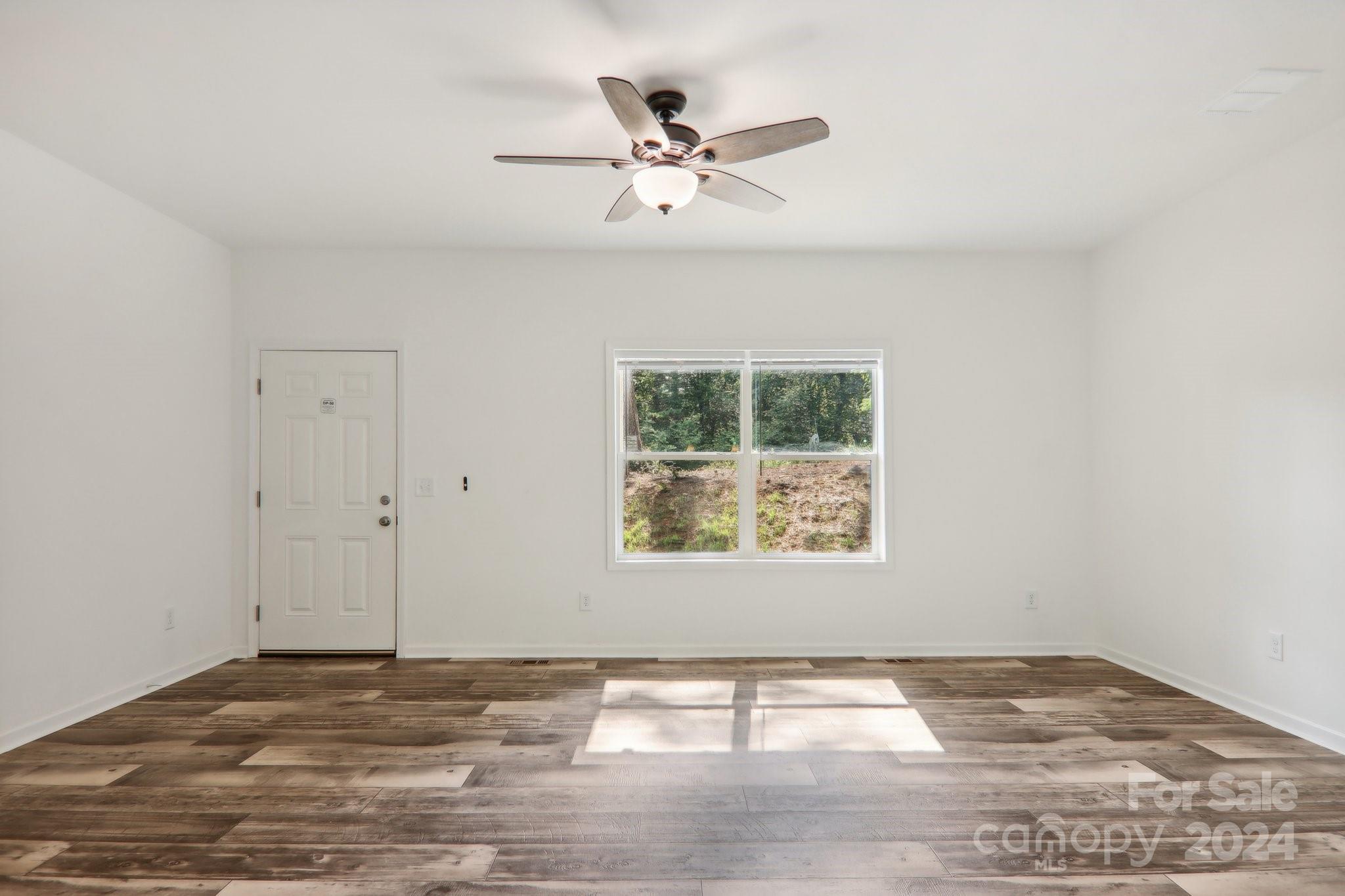 1730 Windswept Ridge Road Marshall, NC 28753 - Photo 18 of 45 a view of an empty room with wooden floor and a window