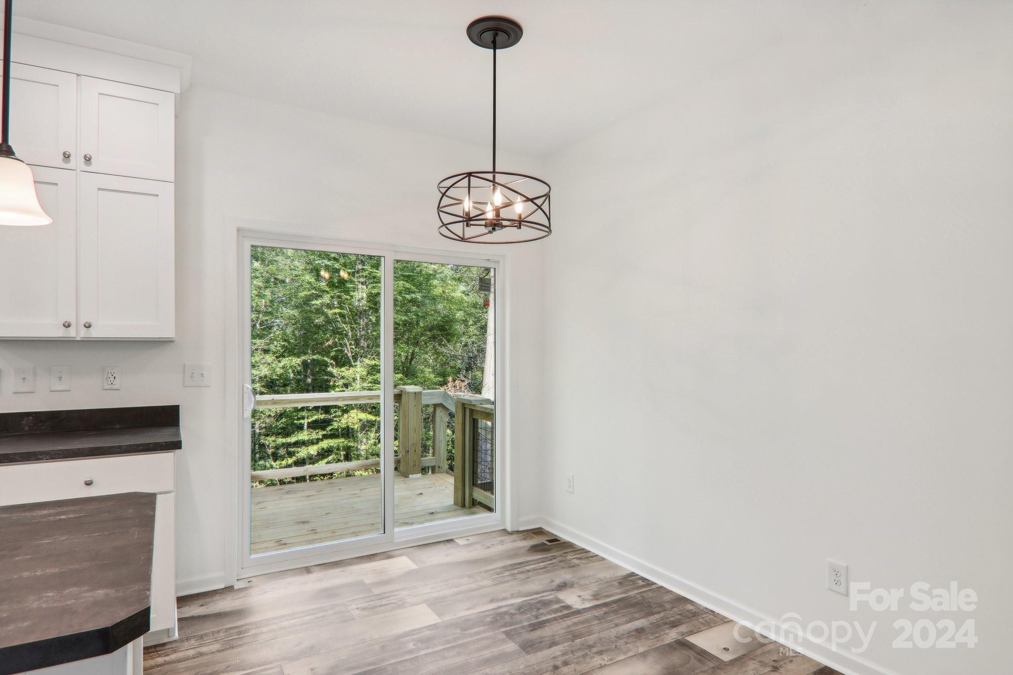 1730 Windswept Ridge Road Marshall, NC 28753 - Photo 27 of 45 a view of an empty room with wooden floor and a window