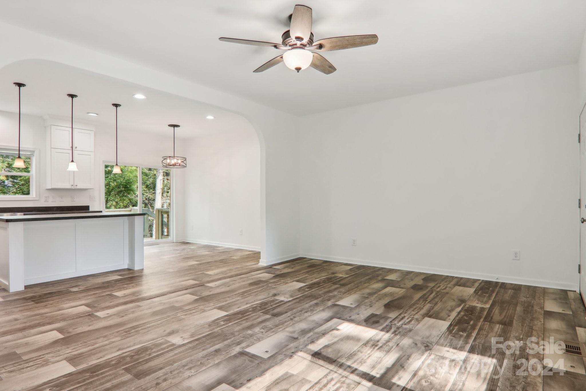 1730 Windswept Ridge Road Marshall, NC 28753 - Photo 9 of 45 a view of a kitchen with kitchen island a sink wooden floor and a chandelier
