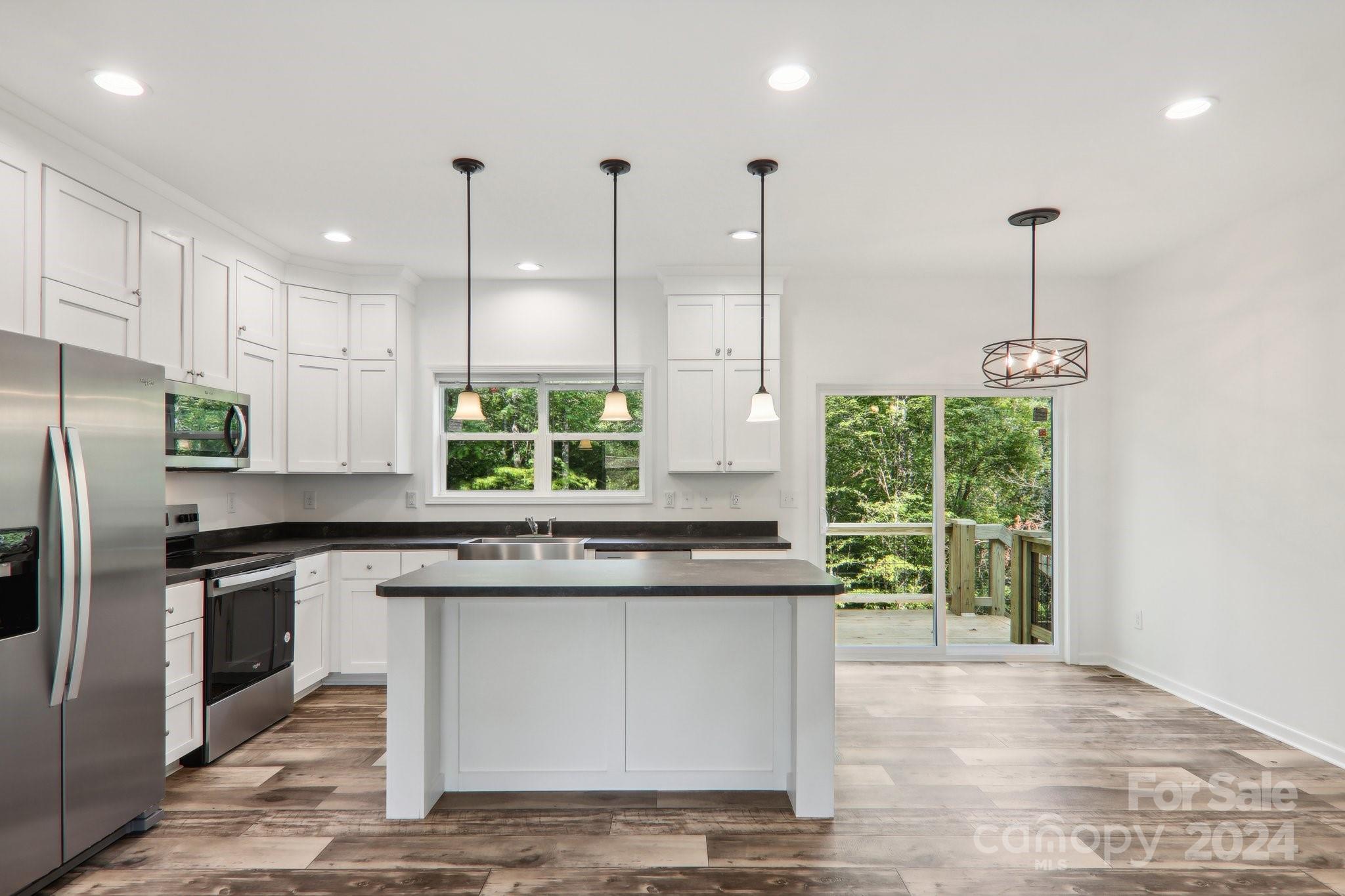 1730 Windswept Ridge Road Marshall, NC 28753 - Photo 10 of 45 a kitchen with stainless steel appliances granite countertop a sink a stove and a wooden floors