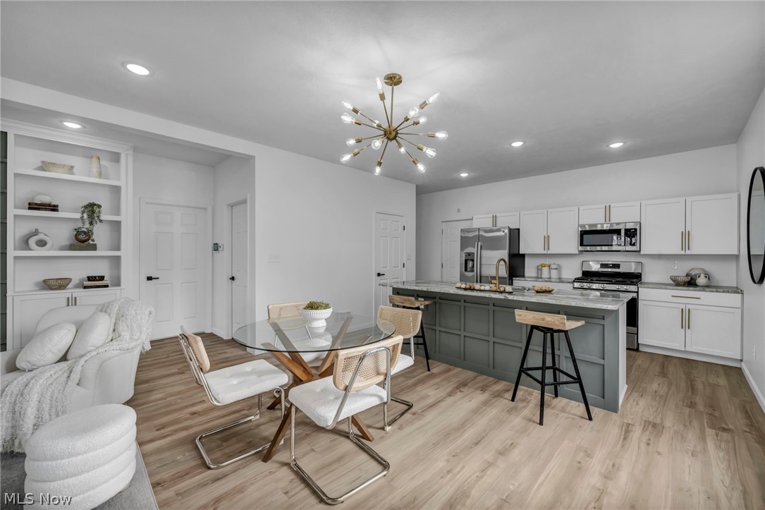 3633 Pennington Road Cleveland, OH 44120 - Photo 14 of 34 Dining space with light wood-style floors, suspended lighting, and built in shelves