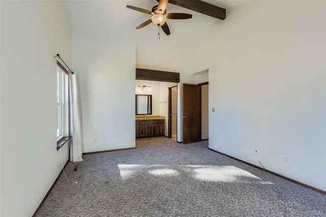 a view of a livingroom with a ceiling fan and window