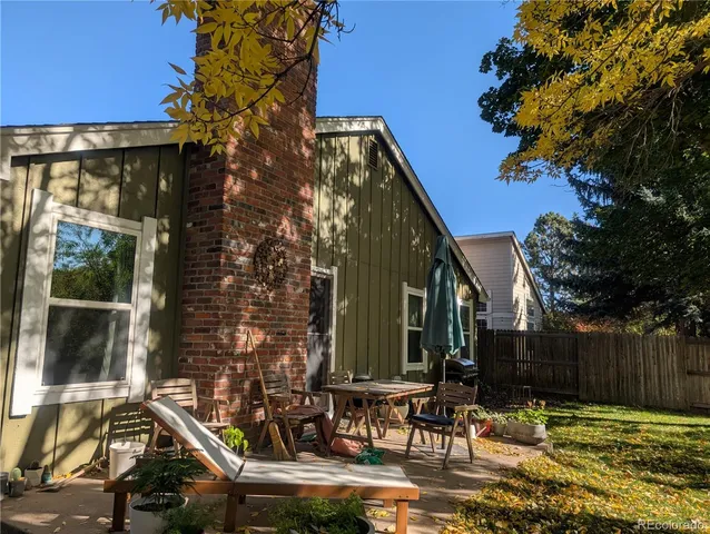 a backyard of a house with table and chairs
