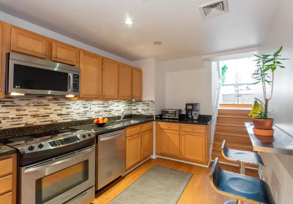 a kitchen with stainless steel appliances a stove a sink and a microwave