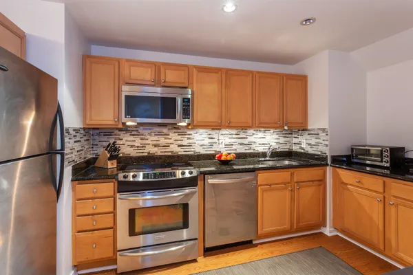 a kitchen with granite countertop a refrigerator stove and microwave