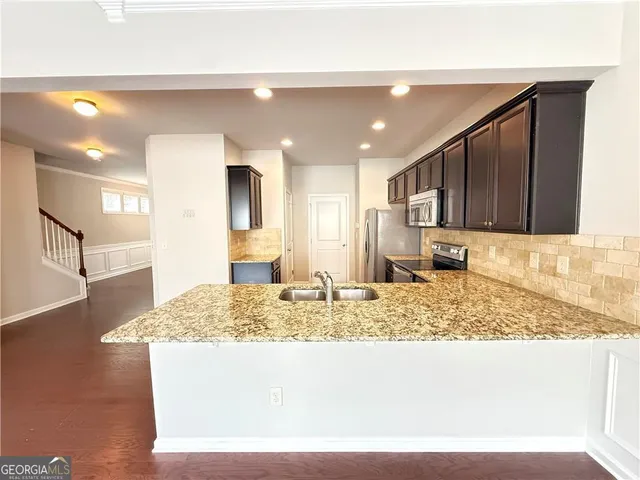 a view of kitchen island kitchen island granite countertop sink and living room