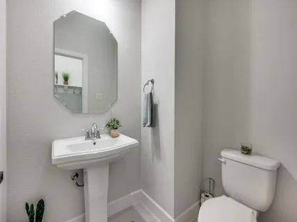 a bathroom with a toilet sink and mirror