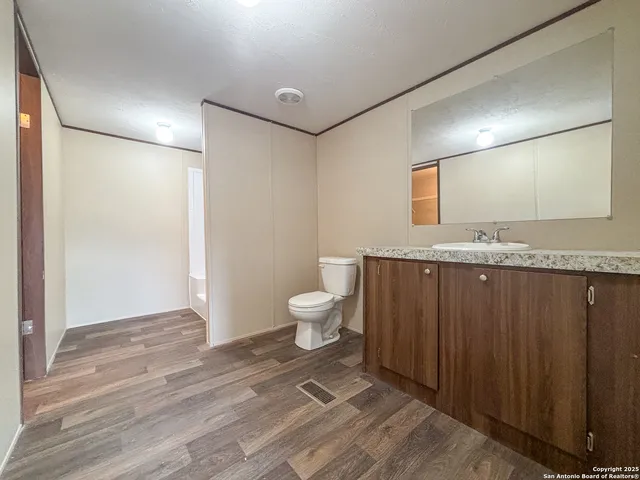 a bathroom with a granite countertop sink toilet and shower