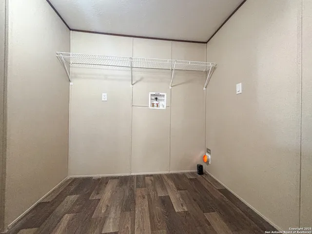 a view of a room with wooden floor and white walls