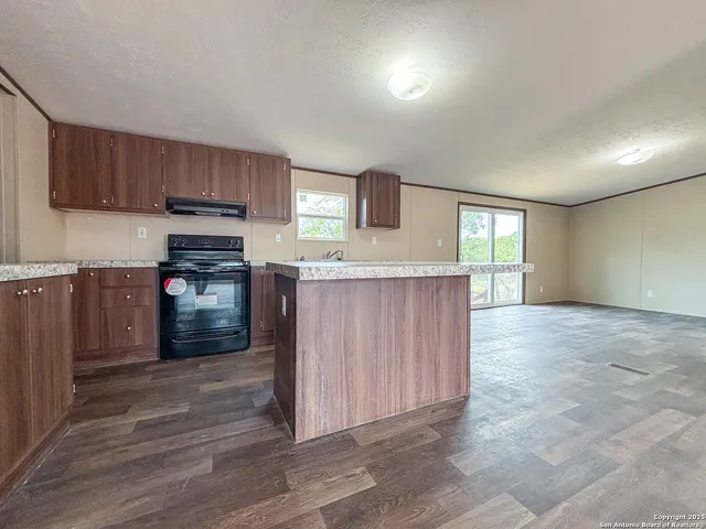 a kitchen with stainless steel appliances granite countertop a stove a sink and a refrigerator