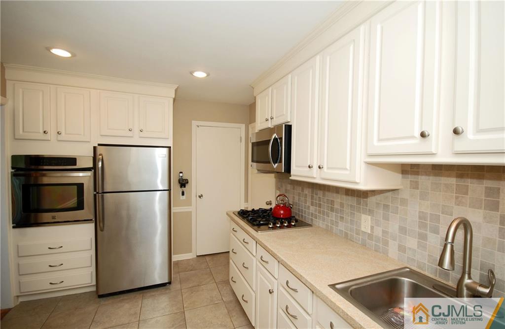 25 Glen Gary Road Middlesex, NJ 08846 - Photo 8 of 21 a kitchen with granite countertop white cabinets and refrigerator