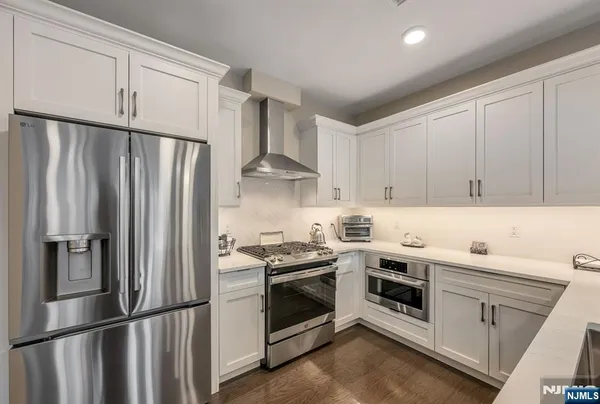 a kitchen with stainless steel appliances a refrigerator sink and cabinets