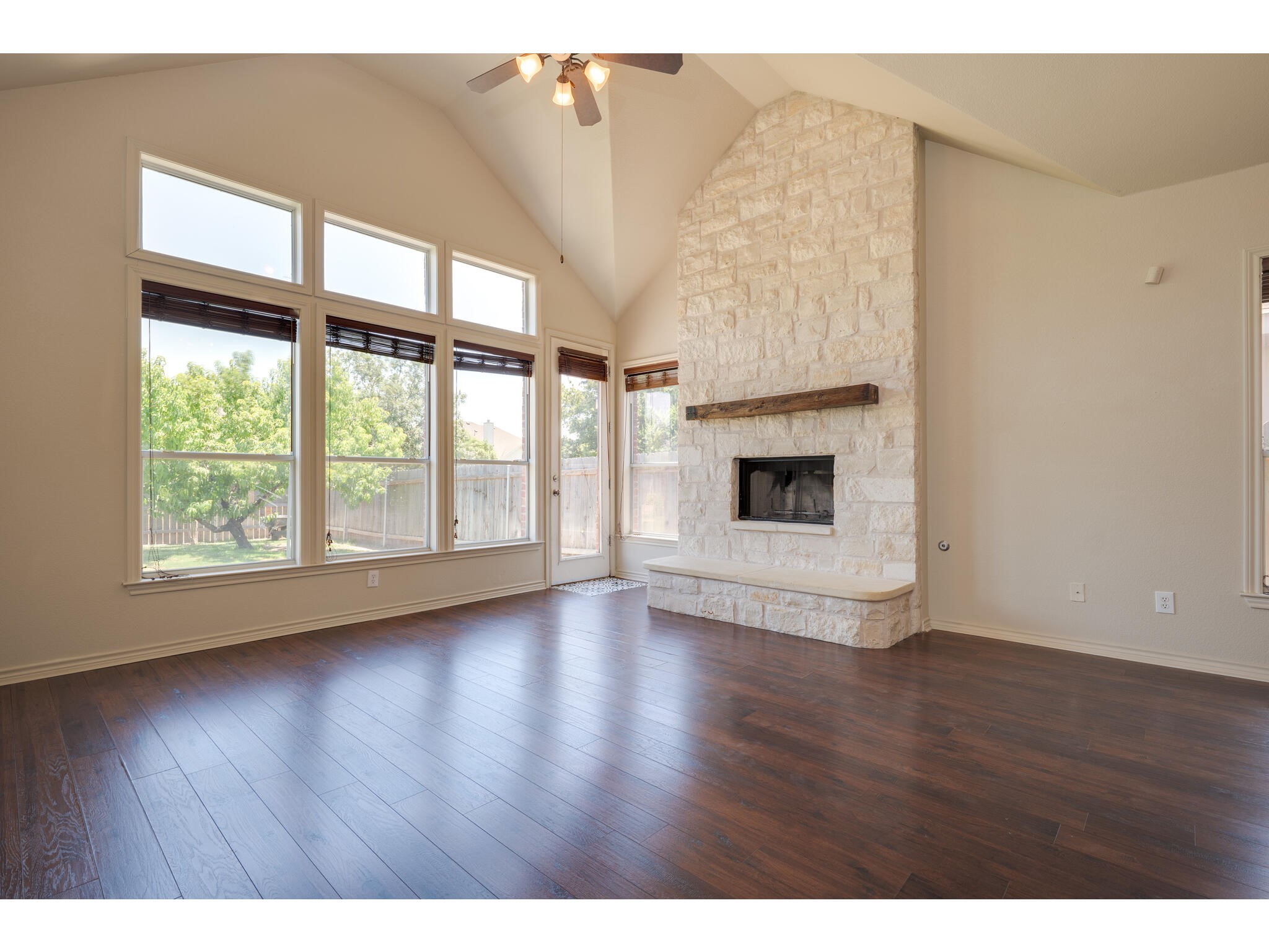 13925 Fallsprings Way Manor, TX 78653 - Photo 11 of 39 a view of an empty room with wooden floor and a window