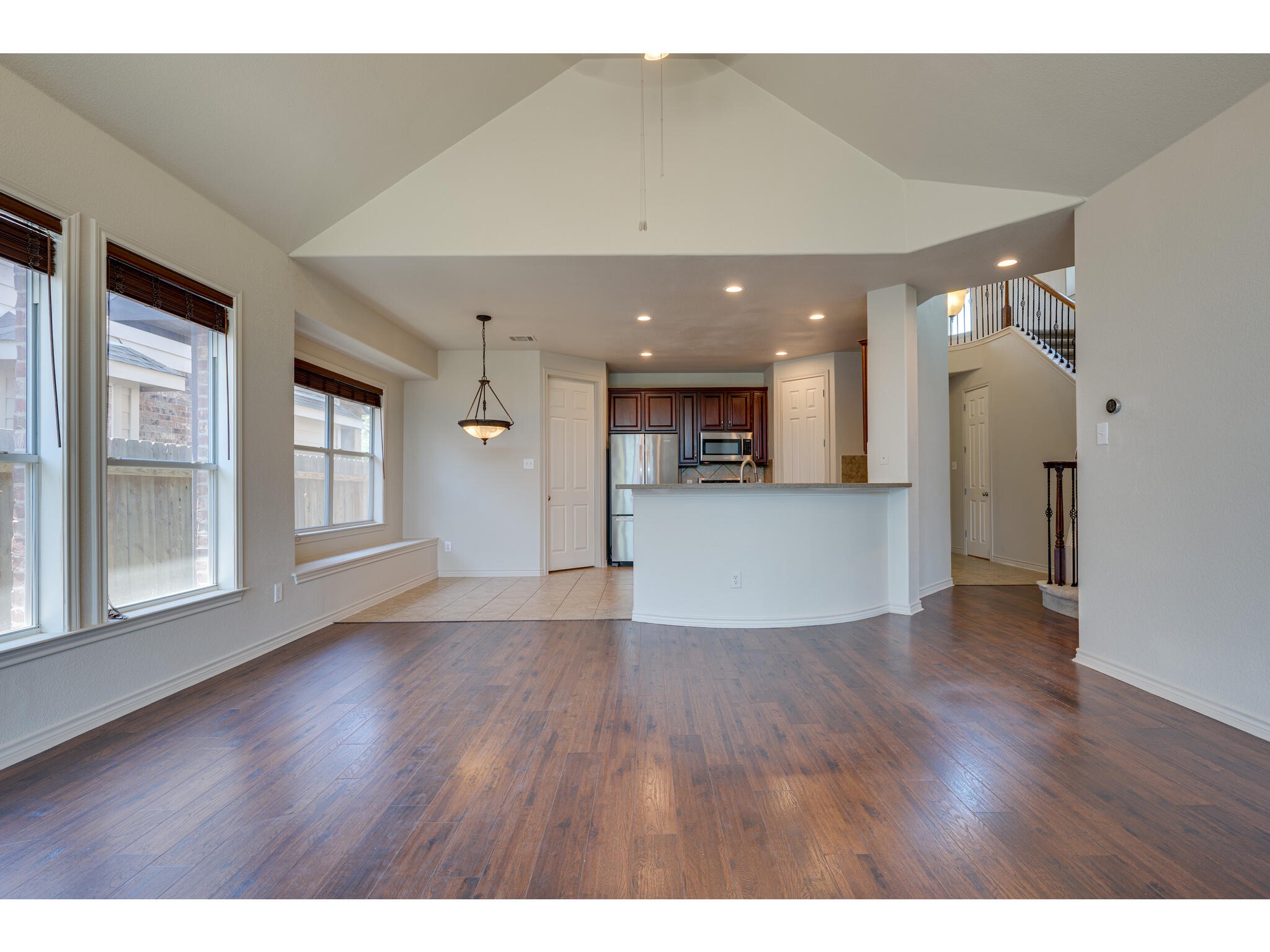 13925 Fallsprings Way Manor, TX 78653 - Photo 14 of 39 a view of a big room with wooden floor and windows