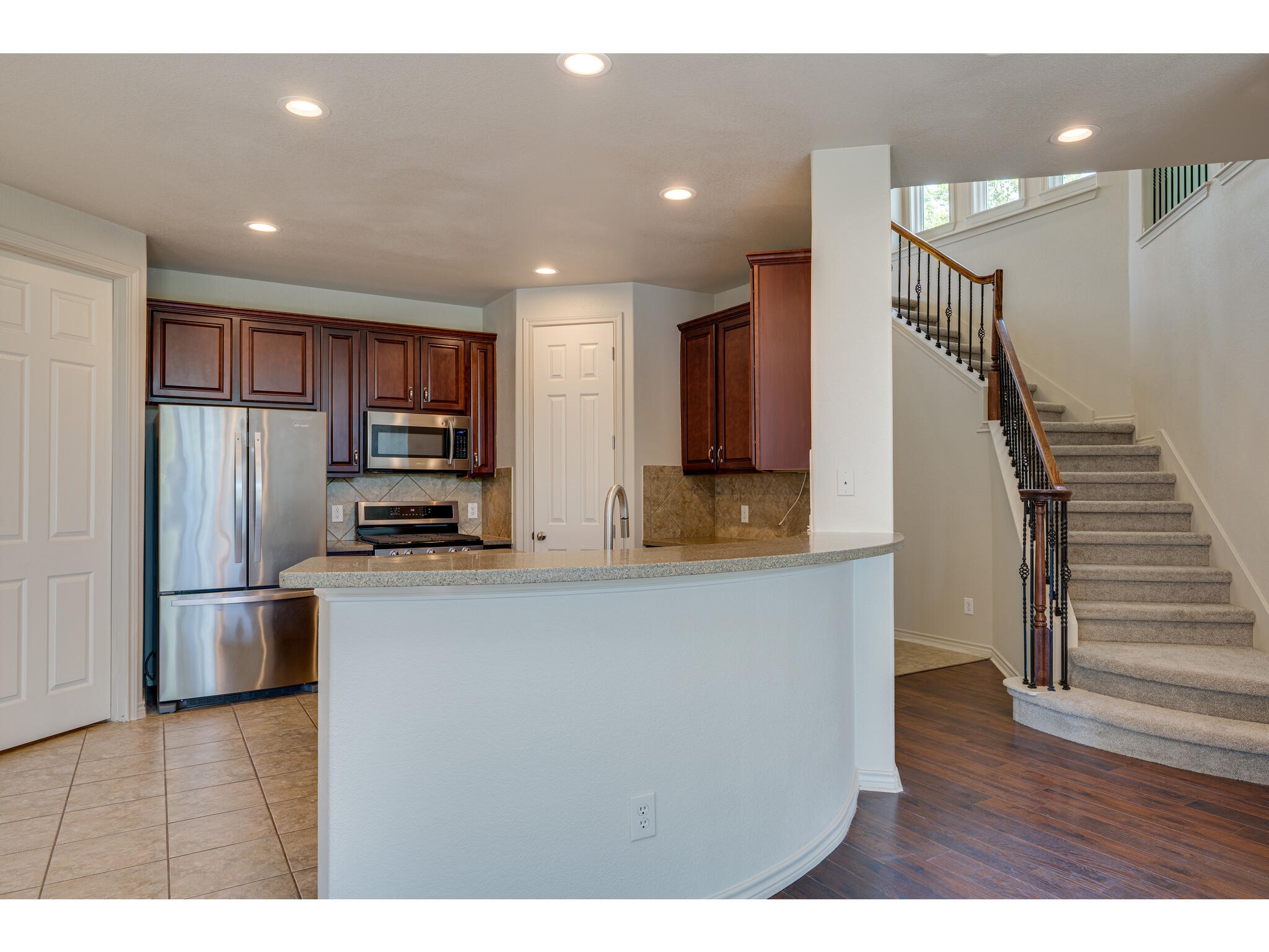 13925 Fallsprings Way Manor, TX 78653 - Photo 15 of 39 a open kitchen with stainless steel appliances a refrigerator and a wooden floor