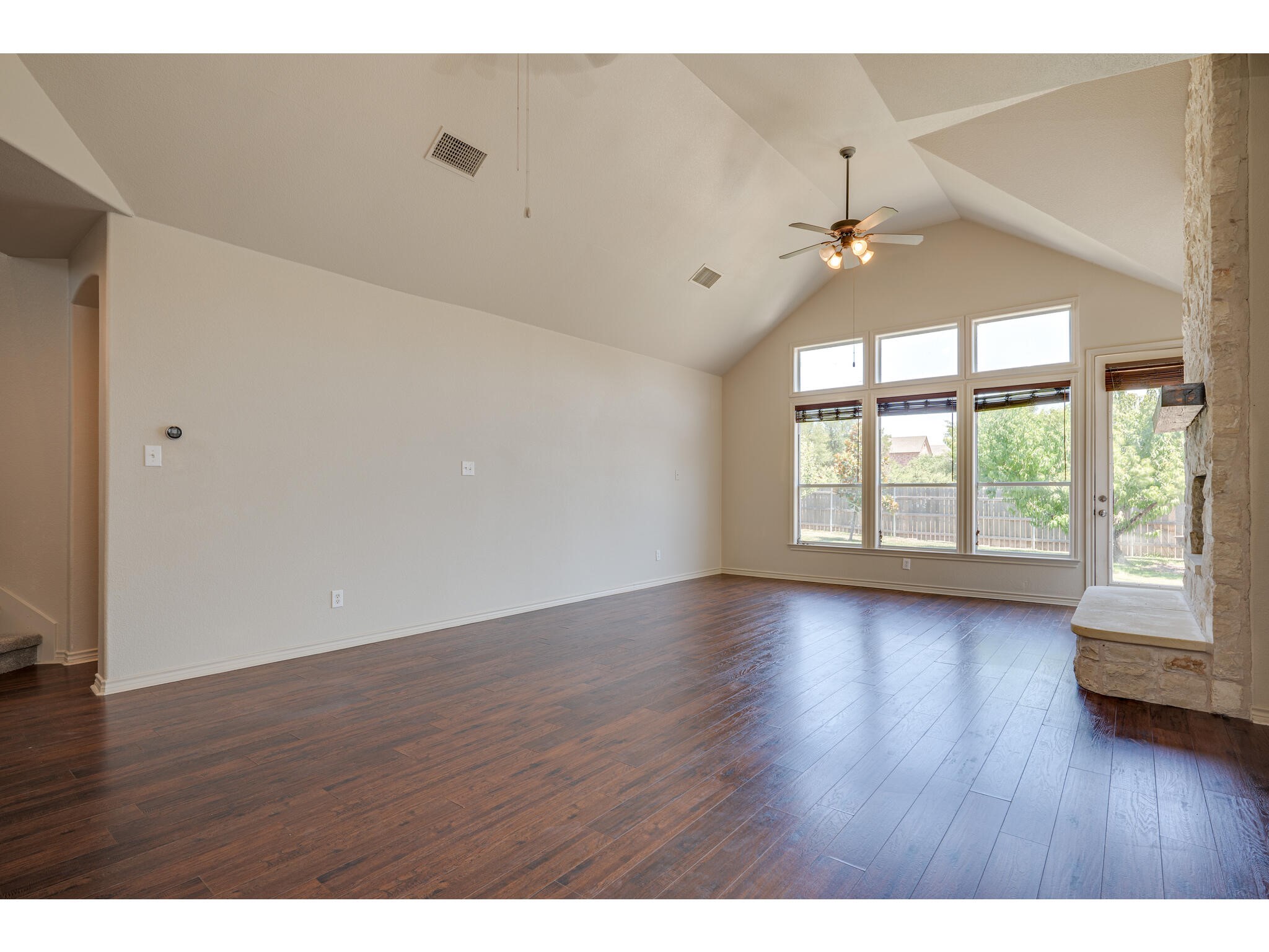 13925 Fallsprings Way Manor, TX 78653 - Photo 16 of 39 a view of an empty room with wooden floor and a window