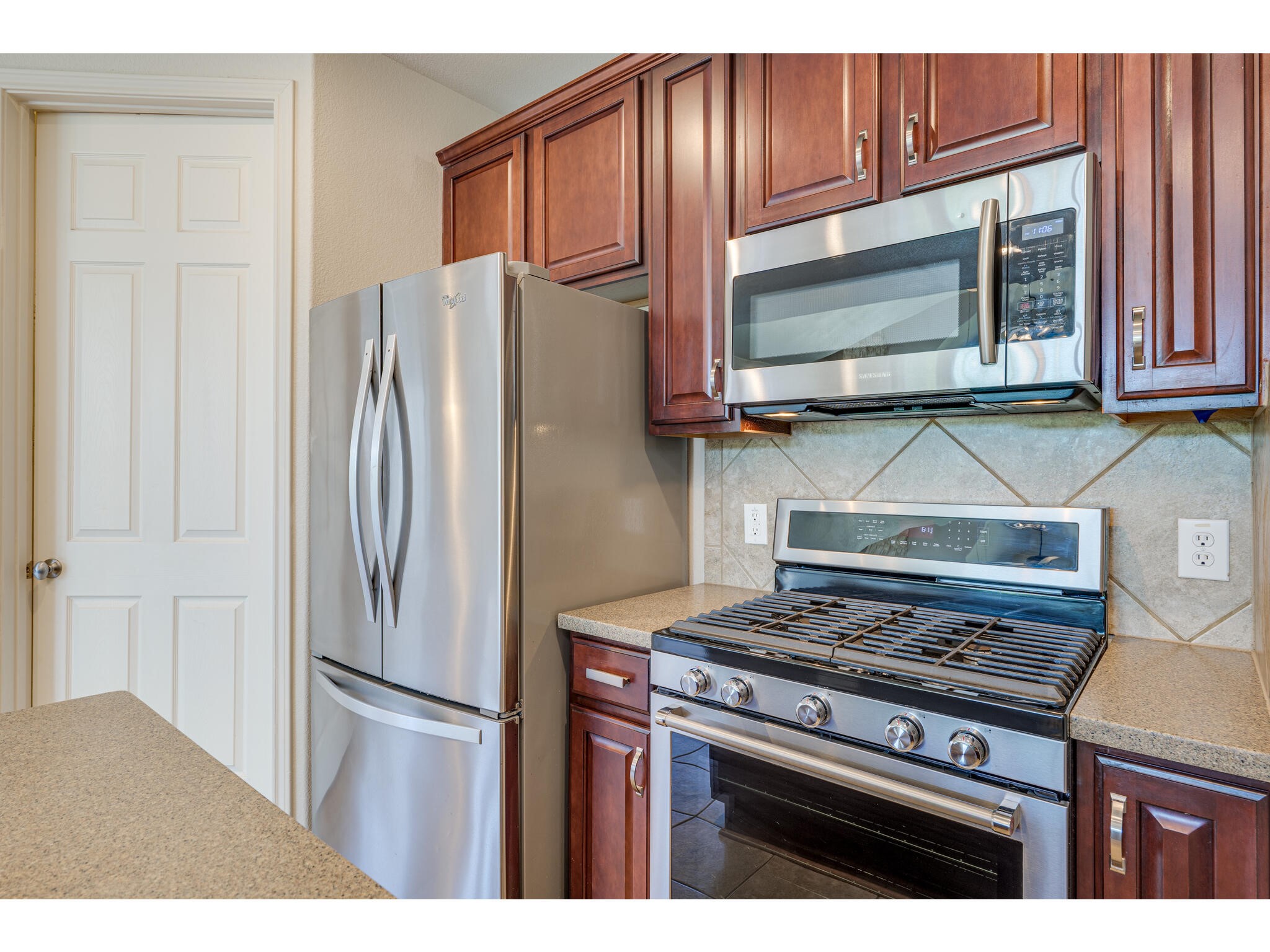 13925 Fallsprings Way Manor, TX 78653 - Photo 19 of 39 a kitchen with granite countertop a refrigerator stove and microwave