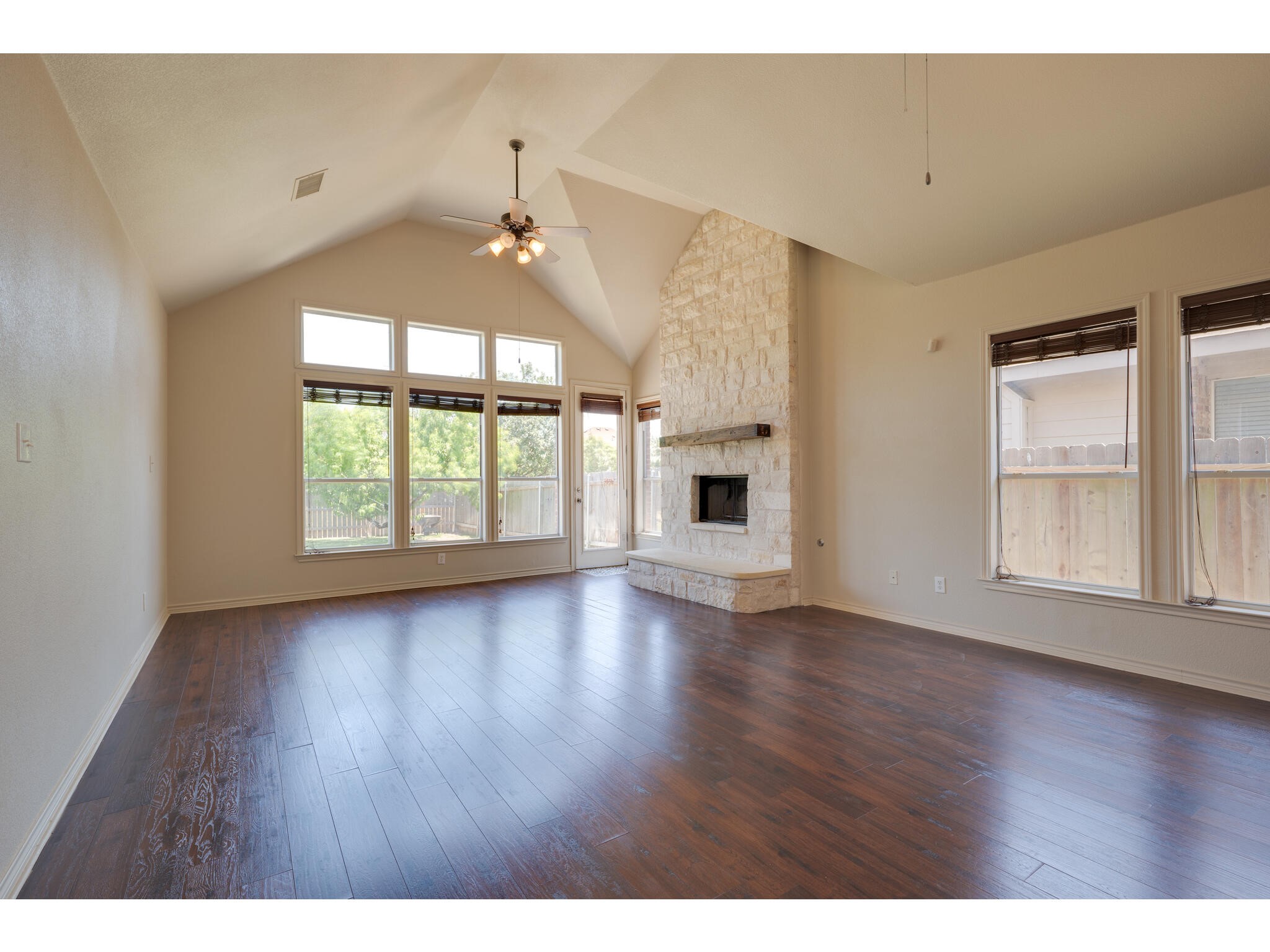 13925 Fallsprings Way Manor, TX 78653 - Photo 4 of 39 a view of an empty room with wooden floor and a window