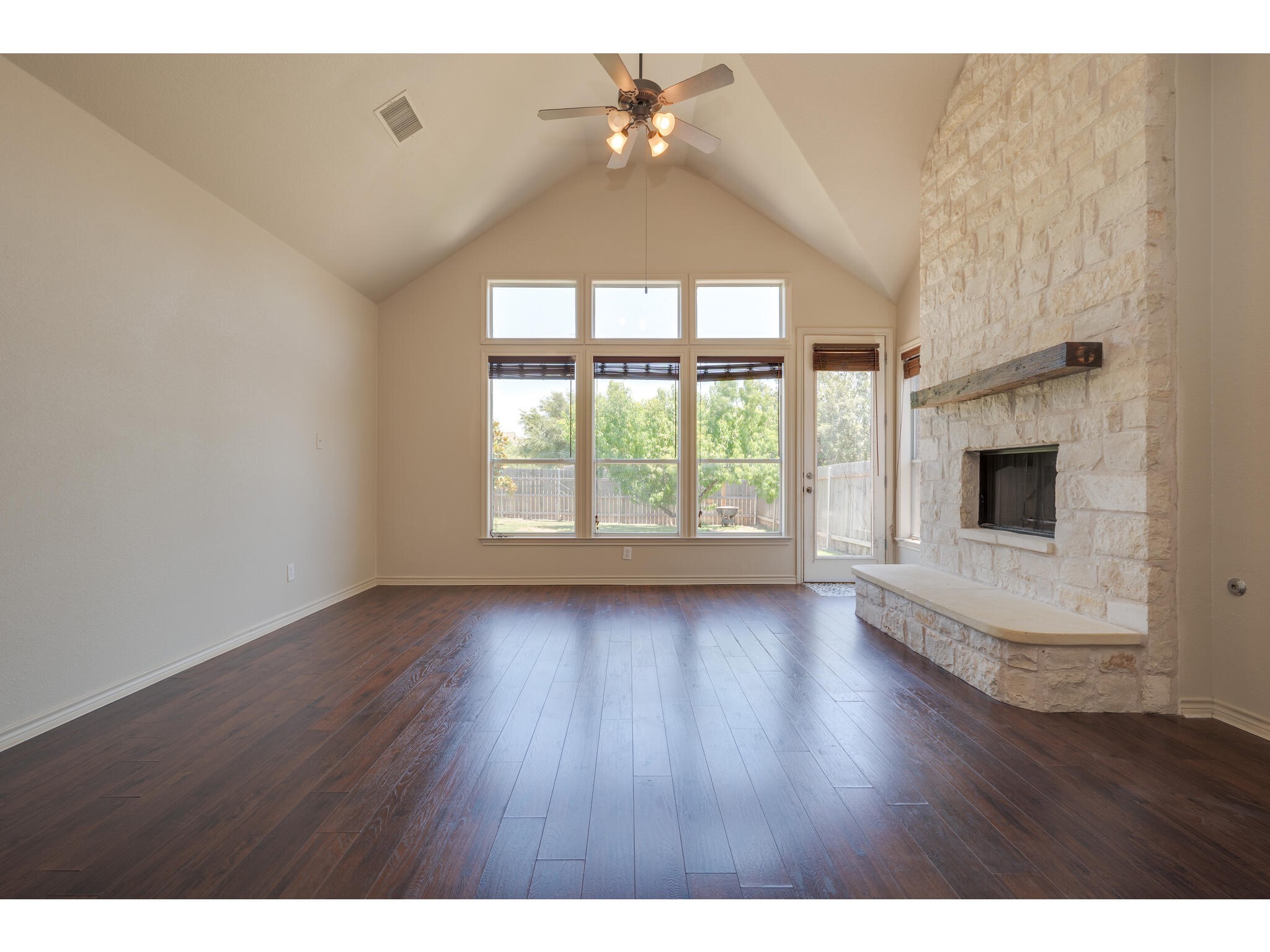 13925 Fallsprings Way Manor, TX 78653 - Photo 10 of 39 a view of an empty room with wooden floor and a window