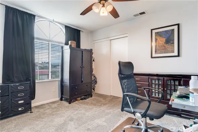 a view of a workspace with furniture and a window