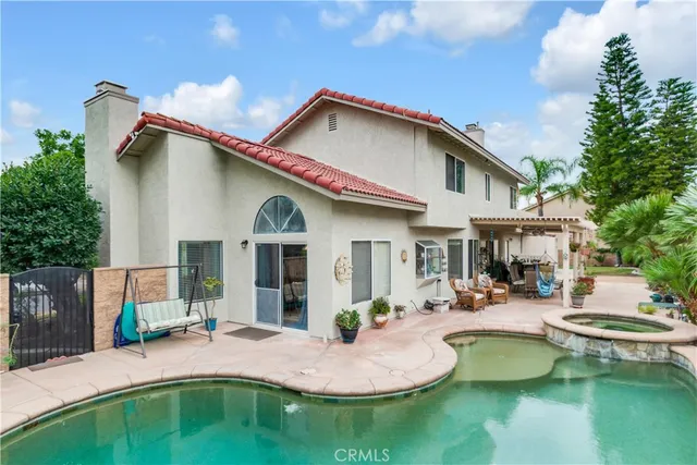 a front view of a house with swimming pool having outdoor seating