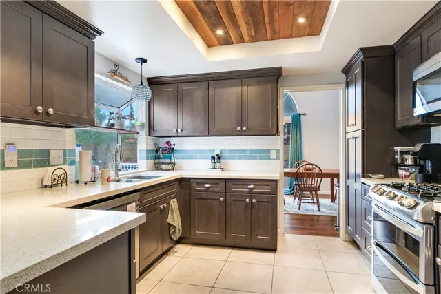 a kitchen with a sink a stove top oven and cabinets