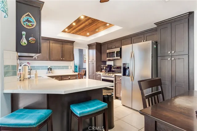 a kitchen with stainless steel appliances a table chairs and refrigerator