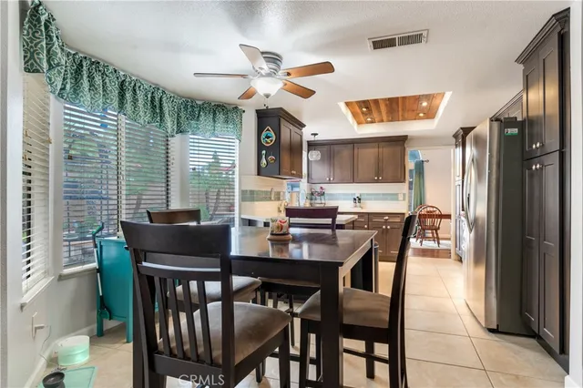 a dining room with stainless steel appliances kitchen island a table chairs and a refrigerator