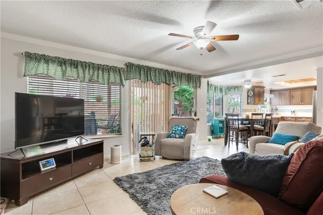 a living room with furniture a flat screen tv and a large window