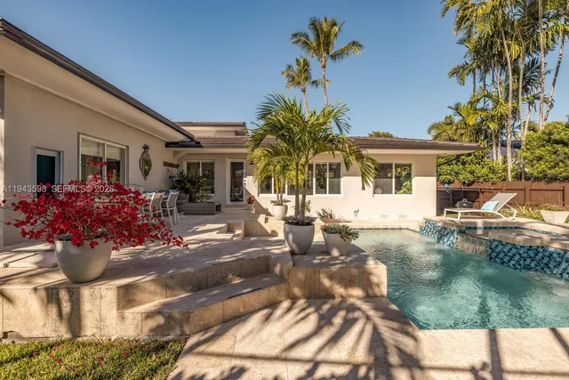 a living room with furniture potted plant and a large window