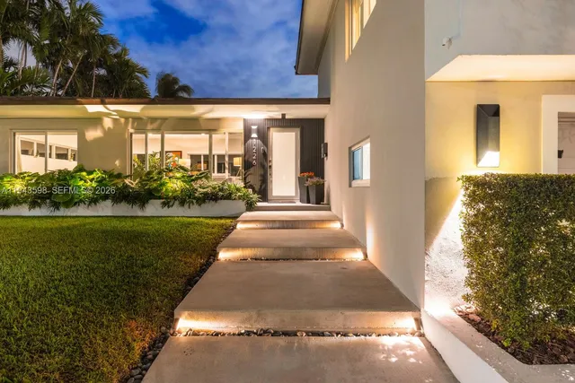 a swimming pool with outdoor seating yard and palm trees
