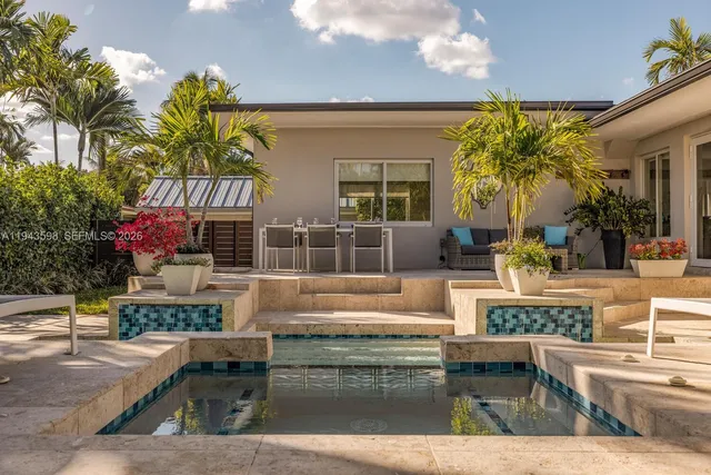 an aerial view of a house with swimming pool and large trees