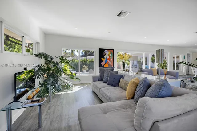 a large kitchen with stainless steel appliances a large counter top a stove a chimney a sink and a center island