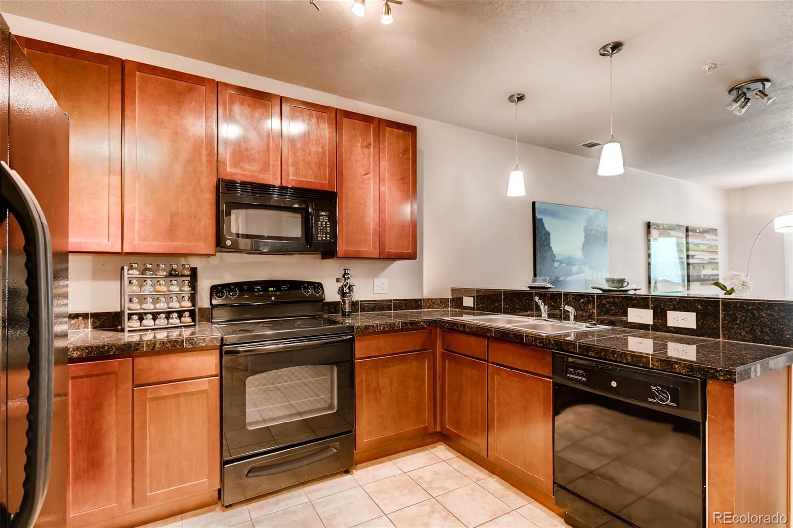 3101 Blake Street, Unit 214 Denver, CO 80205 - Photo 7 of 17 a kitchen with granite countertop stainless steel appliances a sink stove and cabinets