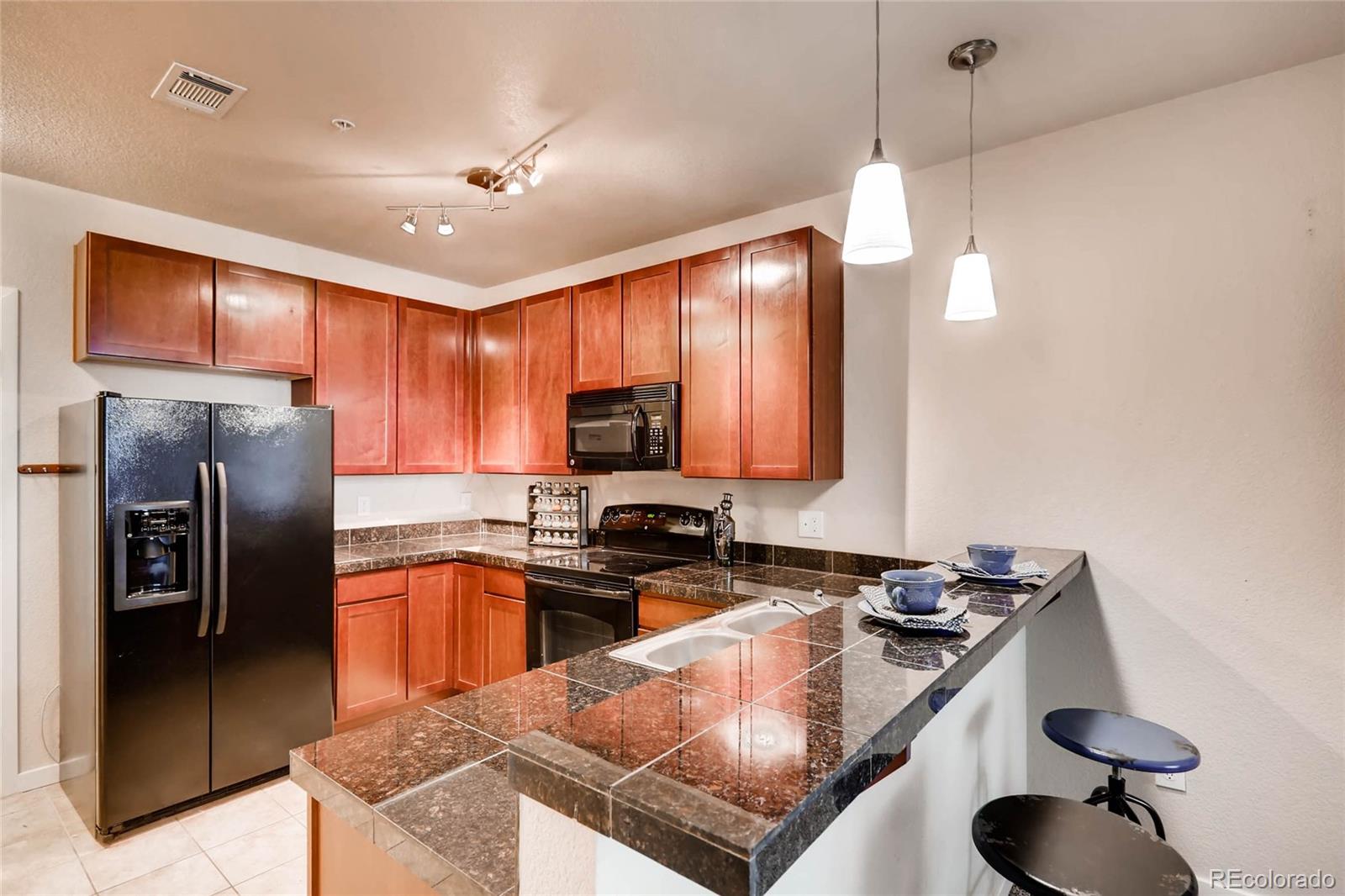 3101 Blake Street, Unit 214 Denver, CO 80205 - Photo 8 of 17 a kitchen with stainless steel appliances granite countertop a sink a stove and refrigerator
