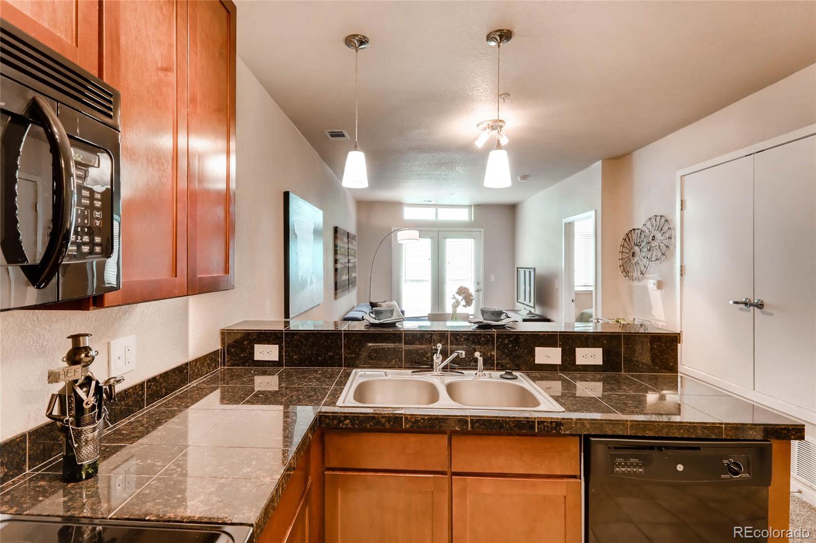 3101 Blake Street, Unit 214 Denver, CO 80205 - Photo 9 of 17 a kitchen with a counter top space a sink and cabinets