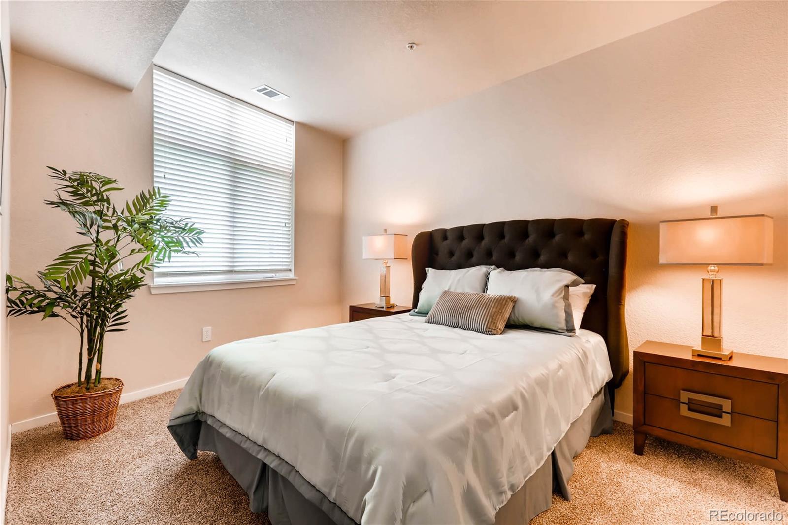 3101 Blake Street, Unit 214 Denver, CO 80205 - Photo 10 of 17 a bedroom with a bed and a potted plant
