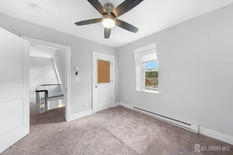 an empty room with windows and fan