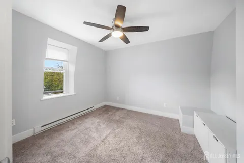 an empty room with a window and a ceiling fan