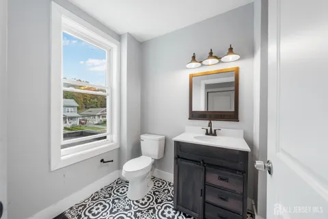 a bathroom with a toilet sink vanity and mirror