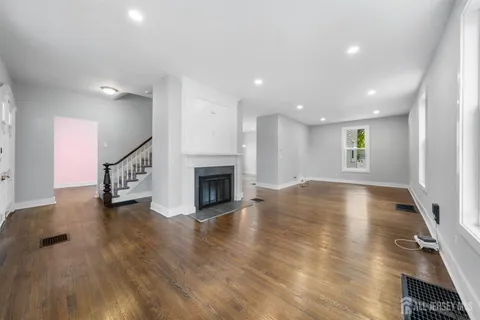 a view of empty room with wooden floor and fireplace
