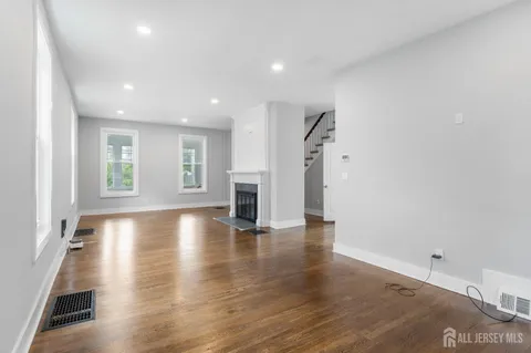 a view of empty room with wooden floor and windows