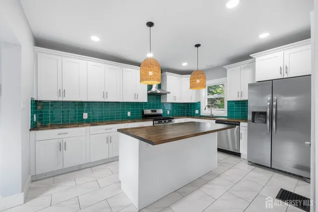 a kitchen with stainless steel appliances granite countertop a sink a stove and a refrigerator