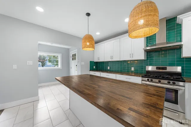 a kitchen with kitchen island granite countertop a stove and a wooden floor
