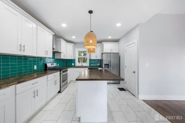 a large kitchen with granite countertop a stove a sink and a refrigerator
